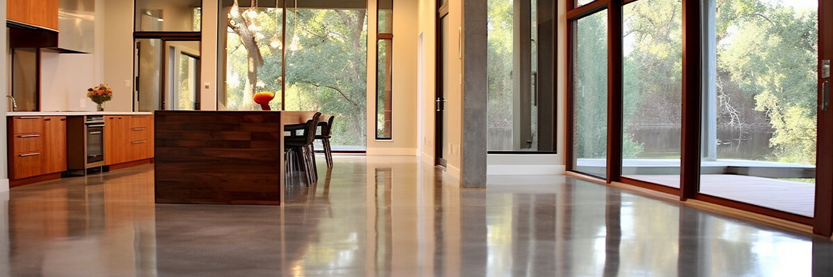 Modern open concept kitchen living room with shiny, polished concrete floors.